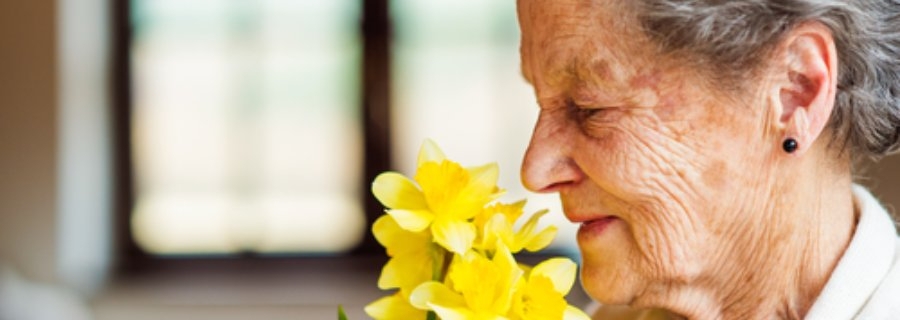 Ouderen ruiken hartige geuren niet meer goed, vrouw ruikt aan bloemen